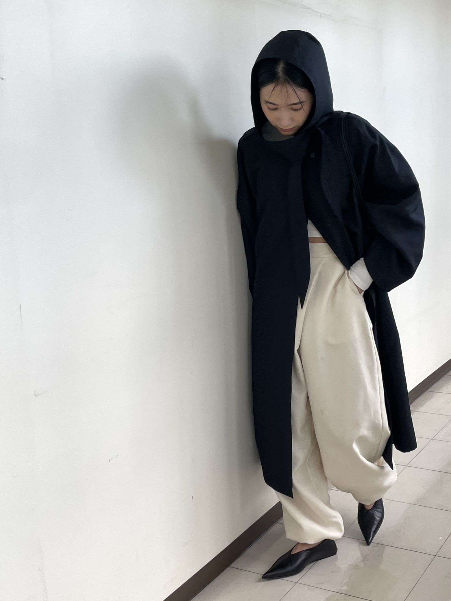 スプリングコートを着用したデザイナー兼革職人の伊地知朋子さん
